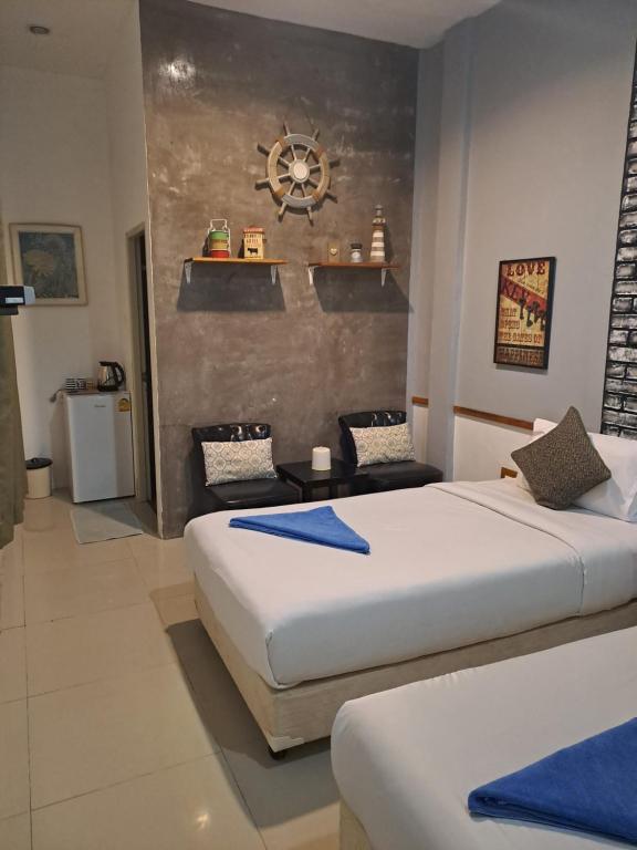 沙美岛班敏妮酒店的一间卧室设有两张床,墙上挂着一个时钟。