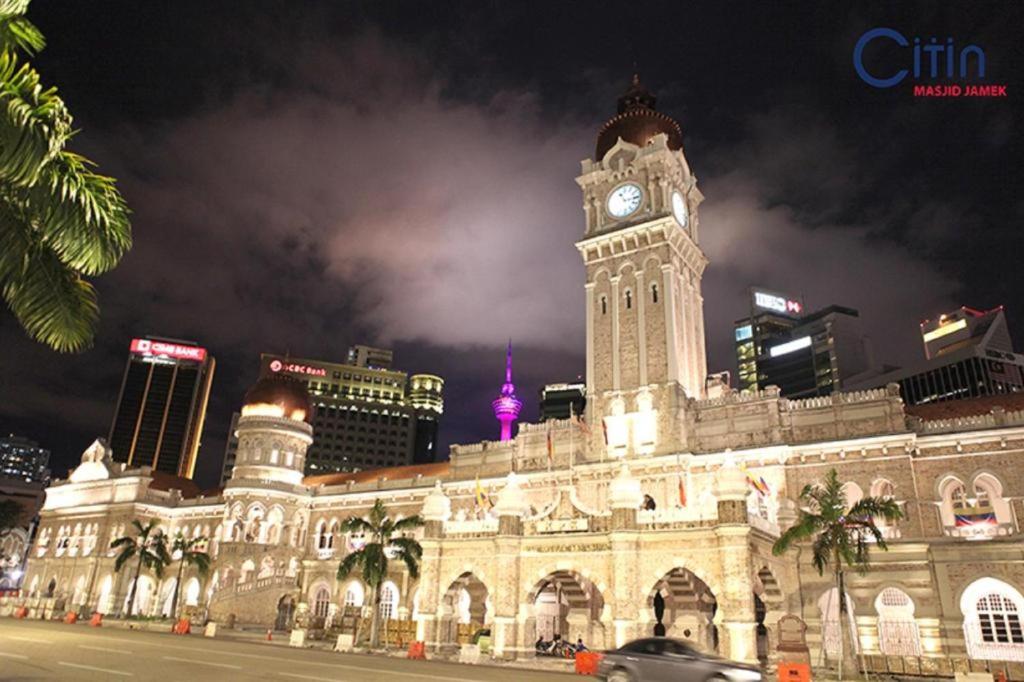 吉隆坡康帕斯酒店集团思庭老清真寺酒店的一座在晚上设有钟楼的大型建筑