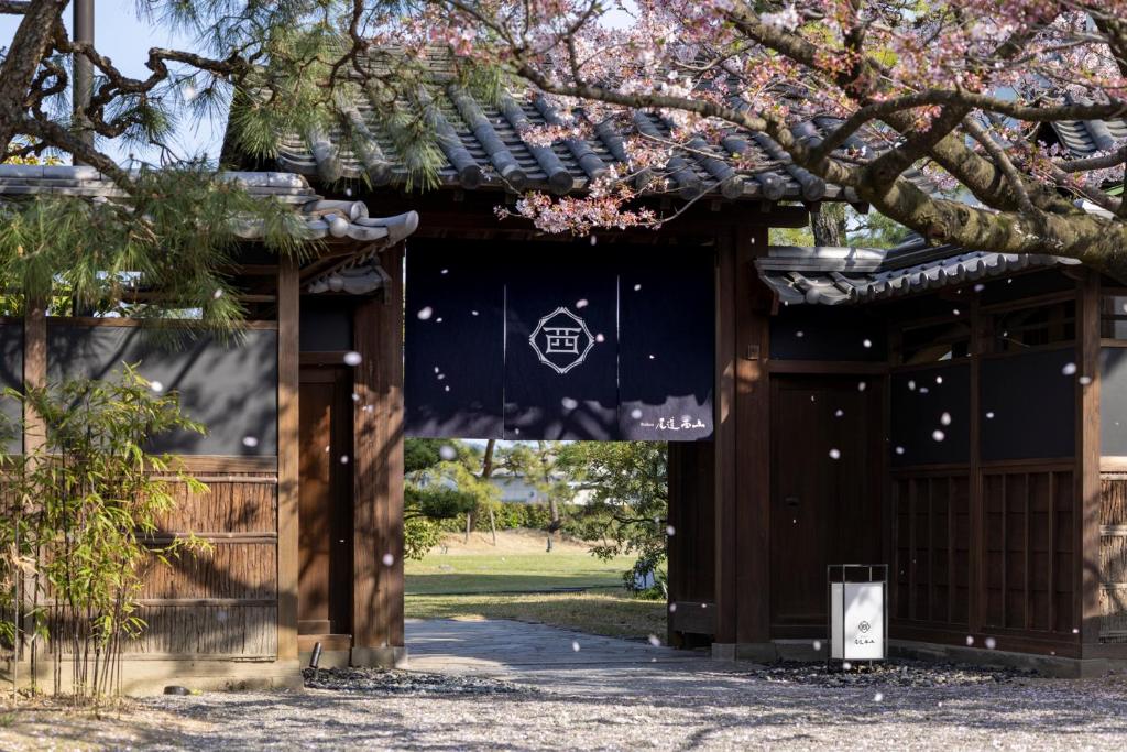 尾道市Ryokan Onomichi Nishiyama的通往公园内有树的寺庙的大门