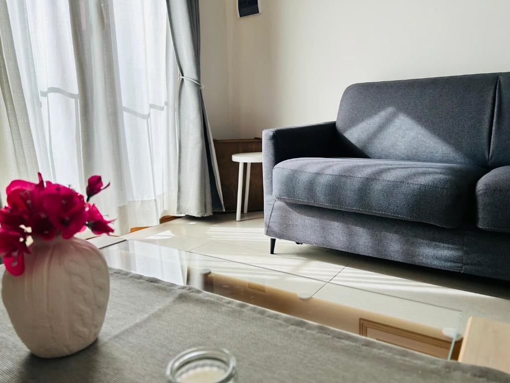 PetrignanoAssisi, Angolo di Matilde的客厅配有沙发和鲜花花瓶