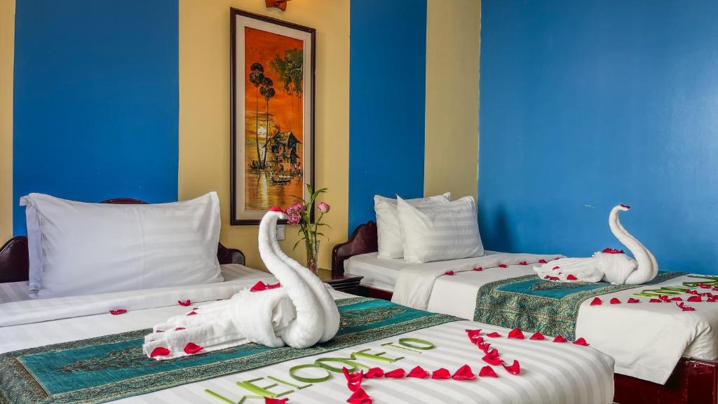 暹粒Harmony Indochine d'Angkor的酒店客房带两张床,还有天鹅