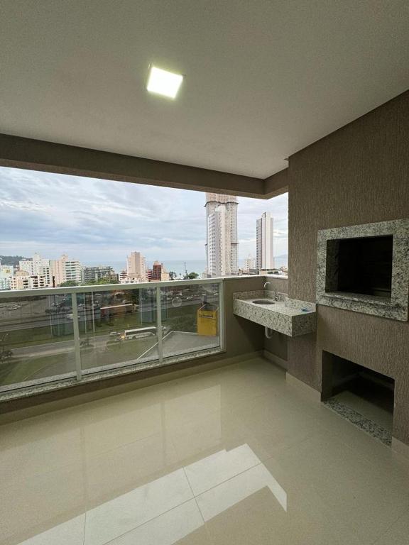 伊塔佩马Apartamento à 390m do Mar的客房设有大窗户,享有城市美景。