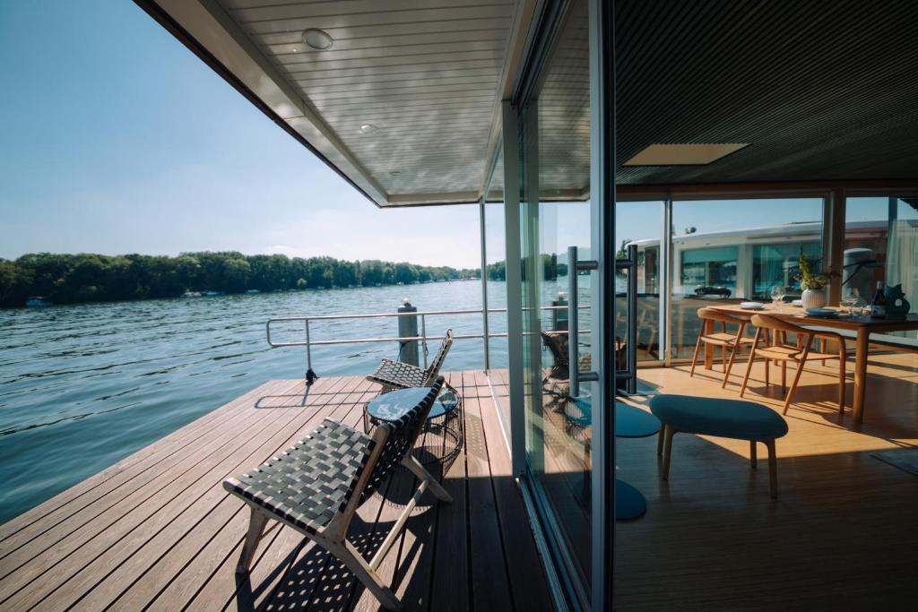 柏林JULIA - Schwimmendes Apartment的船上甲板配有椅子和一张桌子