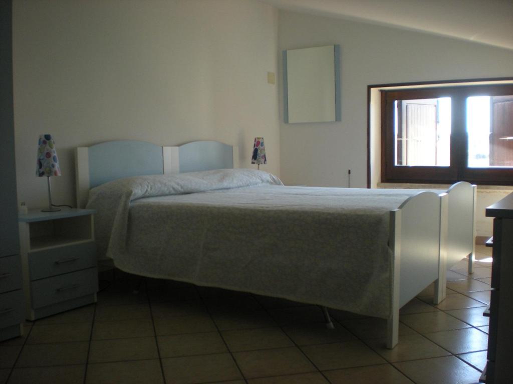 塔维亚诺Casa Bella Vista的一间卧室设有一张大床和一个窗户。