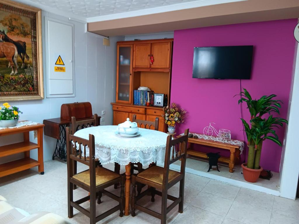 丘利利亚La Replaceta的一间带桌子和粉红色墙壁的用餐室