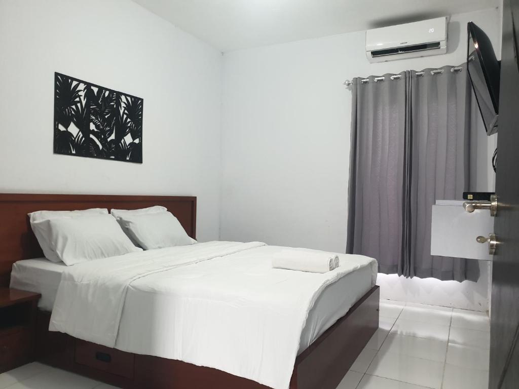 PawenangBTN Mahkota Pemenang 13 Tamarin 3A的卧室设有一张白色大床和一扇窗户。