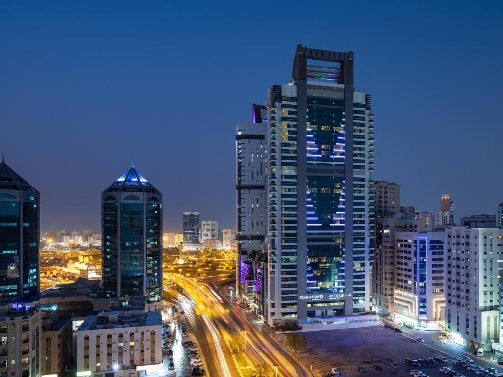 沙迦Four Points by Sheraton Sharjah的城市天际线,晚上有高楼