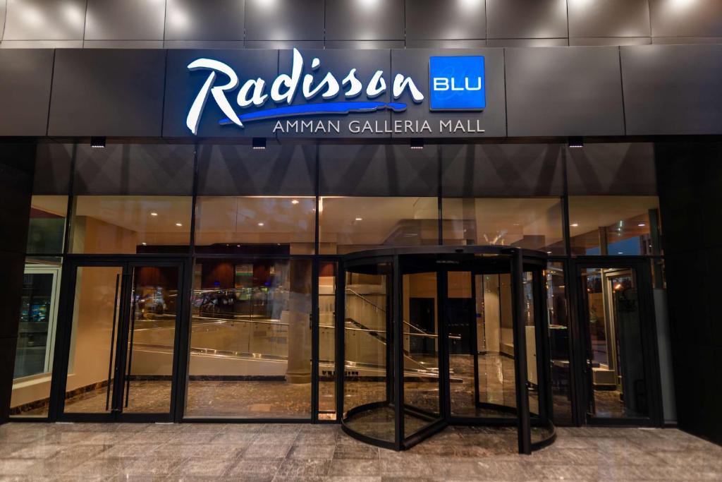 安曼Radisson Blu Hotel, Amman Galleria Mall的建筑的侧面有标志