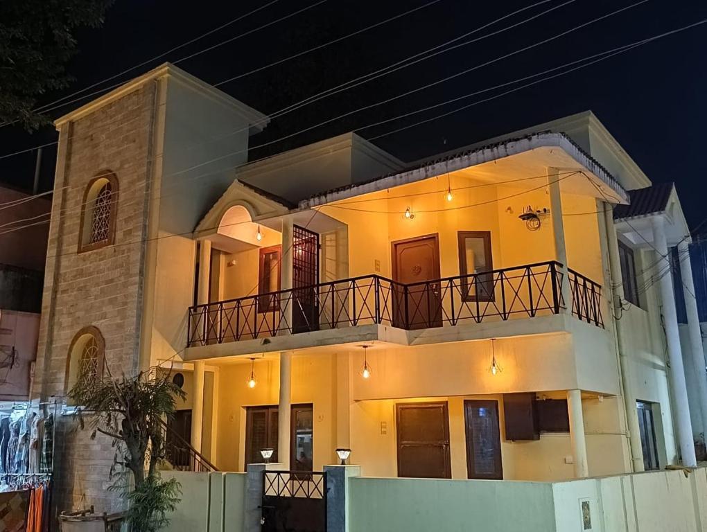 蒂鲁瓦纳马莱Agnisthala Guest House的一间大型白色房子,晚上设有阳台