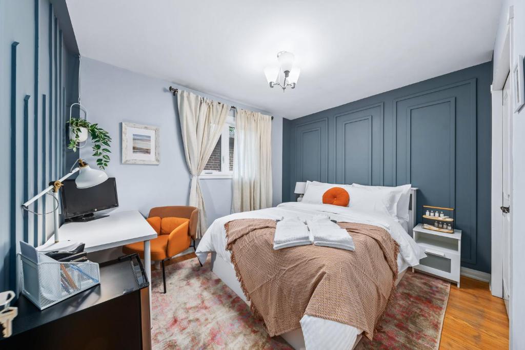 多伦多Large & Sunny Private bedroom in Villa的一间卧室设有蓝色的墙壁、一张床和一张书桌
