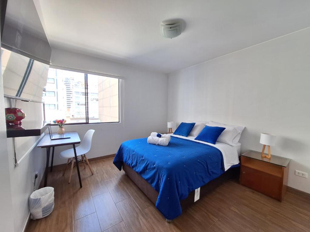 利马Habitacion baño Propio La Paz 1的卧室配有蓝色和白色的床和书桌。