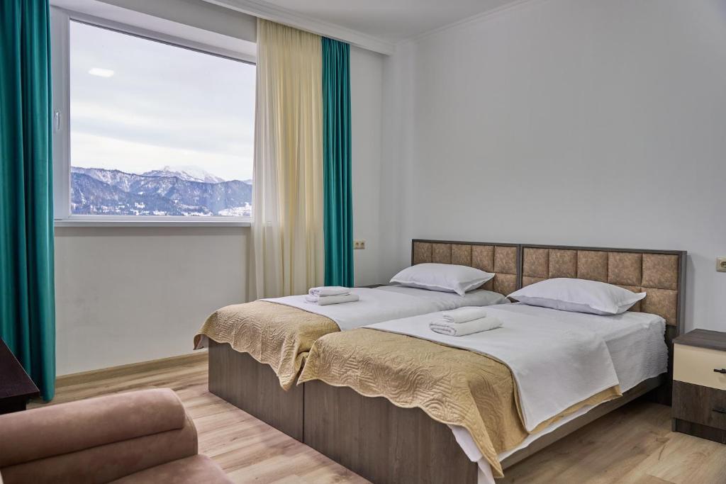 KhuloHotel Lile • სასტუმრო ლილე的一间卧室设有一张大床和一个大窗户