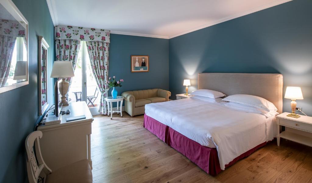 马尔米堡Hotel Franceschi的一间卧室配有一张带蓝色墙壁的大床