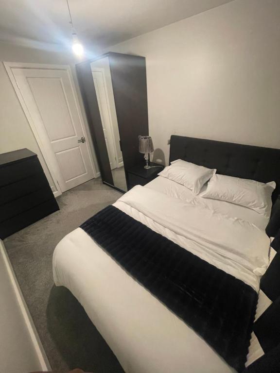 伊普斯威奇Beautiful en-suite bedroom的一间卧室配有一张大床,提供黑白毯子