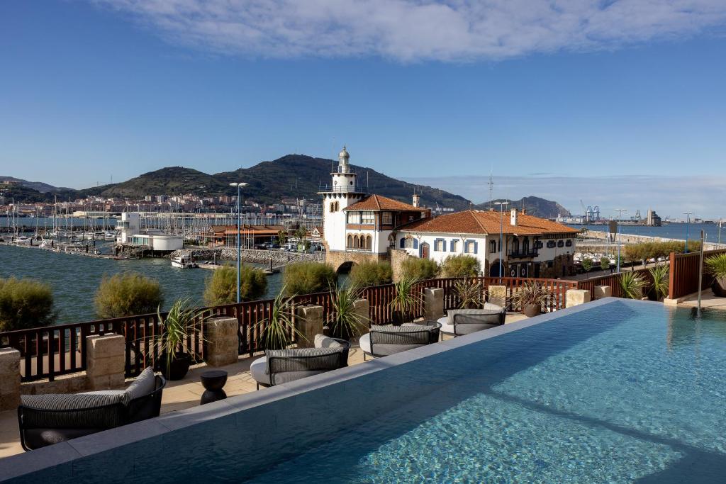 格乔Palacio Arriluce Hotel的游泳池位于大楼顶部,享有水景