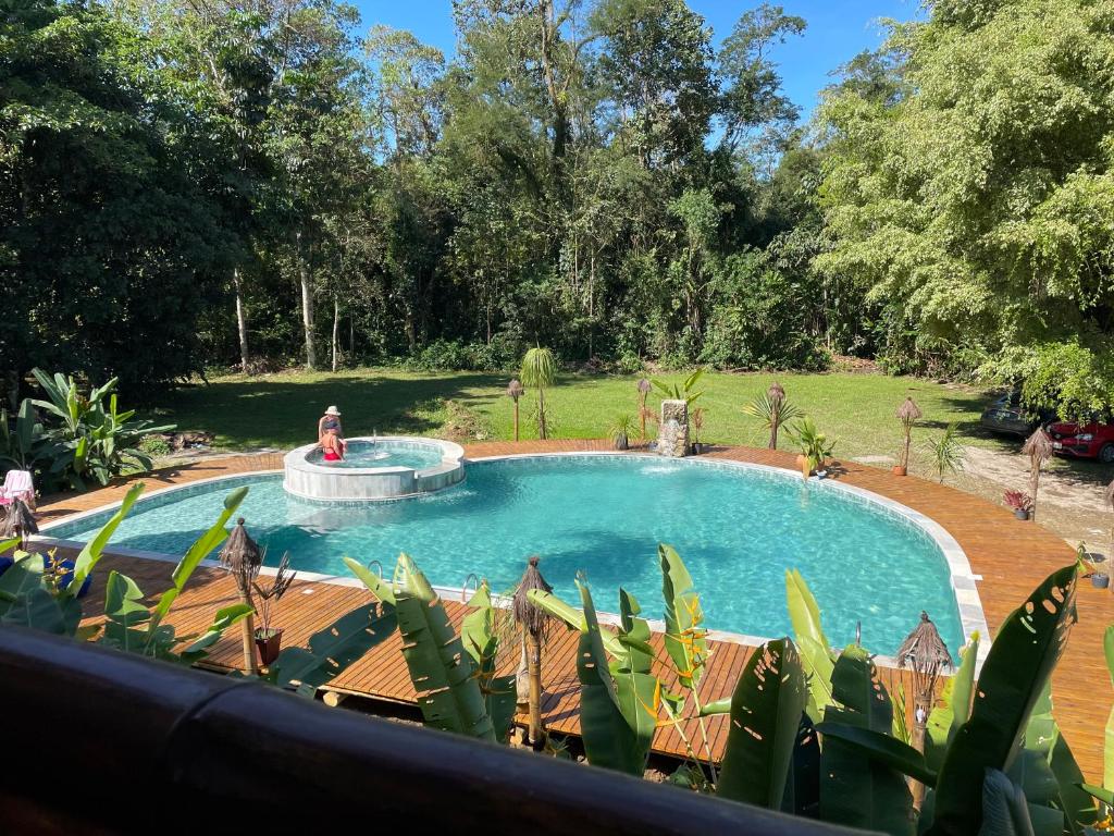 乌巴图巴Bali Suites Itamambuca的庭院中一个带喷泉的游泳池