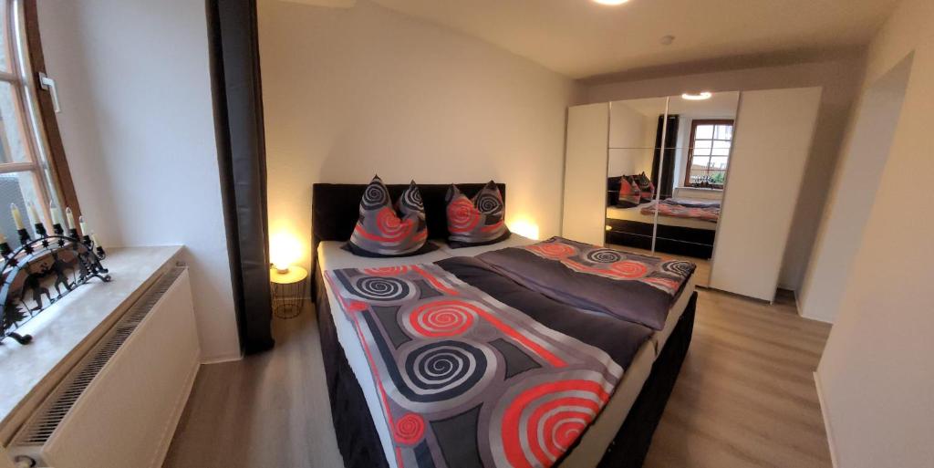 施内贝格Ferienwohnung EG Frauenmarkt 1的一间卧室配有一张大床,床上配有色彩缤纷的枕头