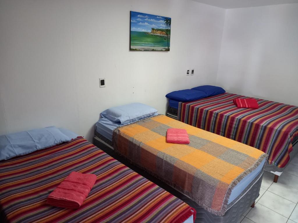若昂佩索阿Pousada Aconchego do Tambaú的一间房间,有三张床