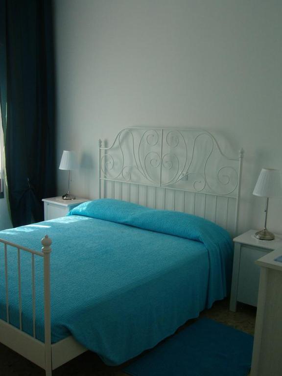 格拉多Appartamenti Condominio Daniele的一间卧室配有一张带蓝色毯子的床