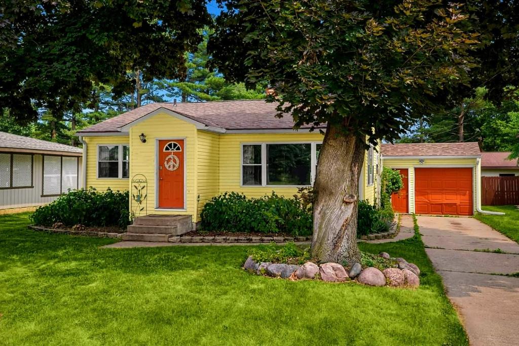 拉克罗斯French Island Home Whot Tub, Kayak, Lake View的黄色的房子,有红门和一棵树