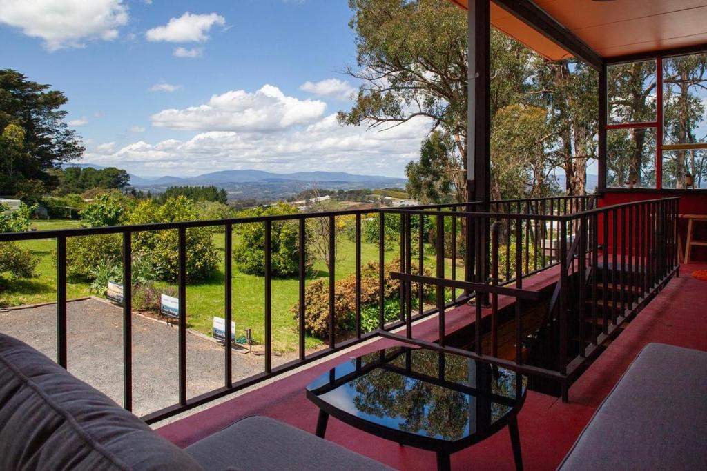 SilvanVista Suite Treetops Silvan Valley Lodge的阳台,配有一张沙发和一张桌子