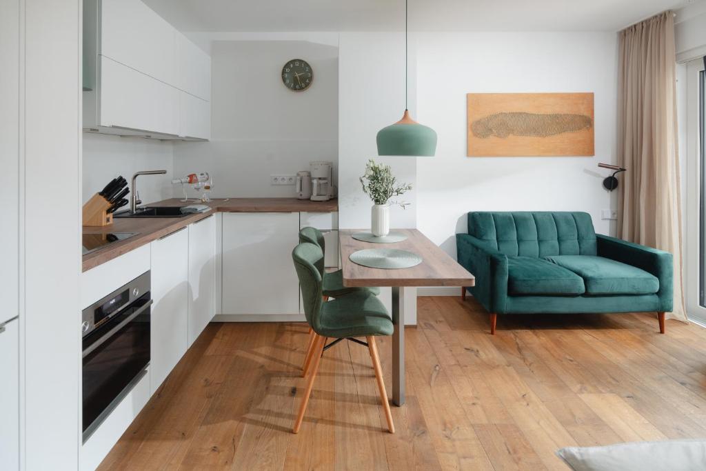 诺德奈Haus Noena - Wohnung 7 Inselschatz的厨房配有桌子和绿色椅子