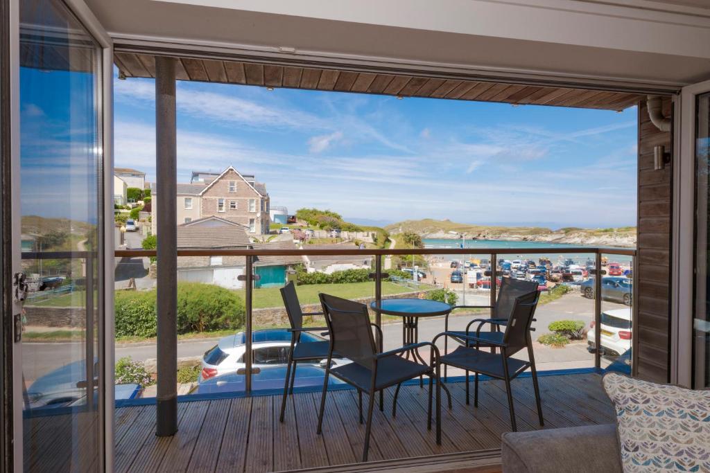 纽基The Beach House & Porth Sands Apartments的阳台配有桌椅,享有海景。