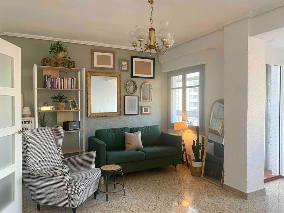 萨拉戈萨Acogedor apartamento a 5 min del Ave的客厅配有绿色沙发和椅子
