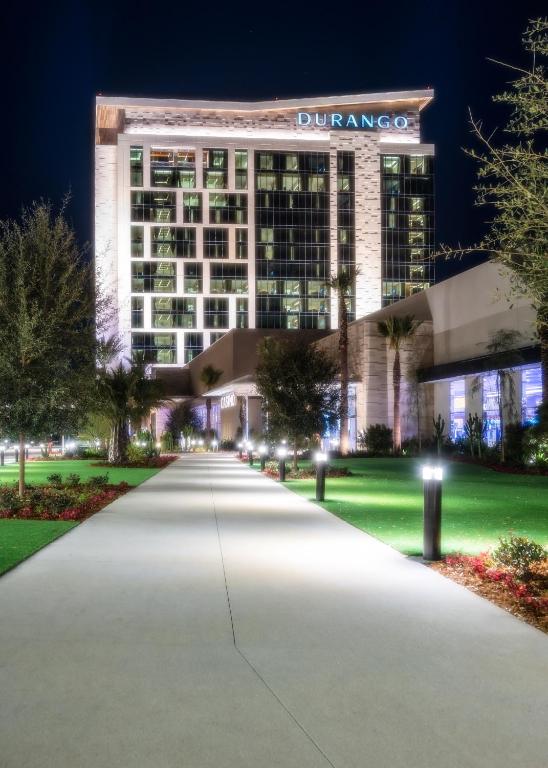 拉斯维加斯Durango Casino &amp; Resort的一座建筑在晚上点燃,有长车道