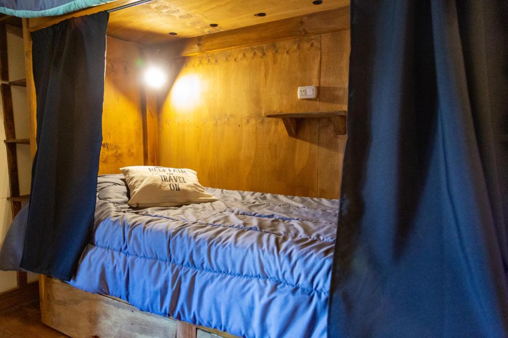 埃博森Hostel Cosmo的蓝色窗帘的房间的一张床位