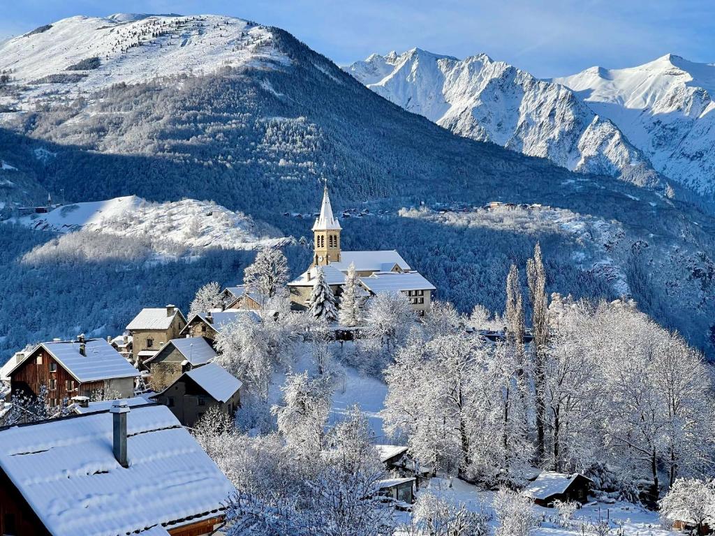 MizoënChalet Le Panoramique的一座雪中教堂,背景是群山