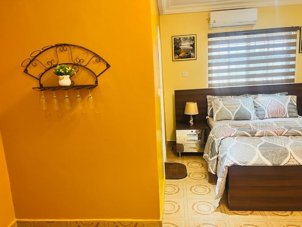 AshalebotweAJ Homes的一间卧室设有一张床和黄色的墙壁