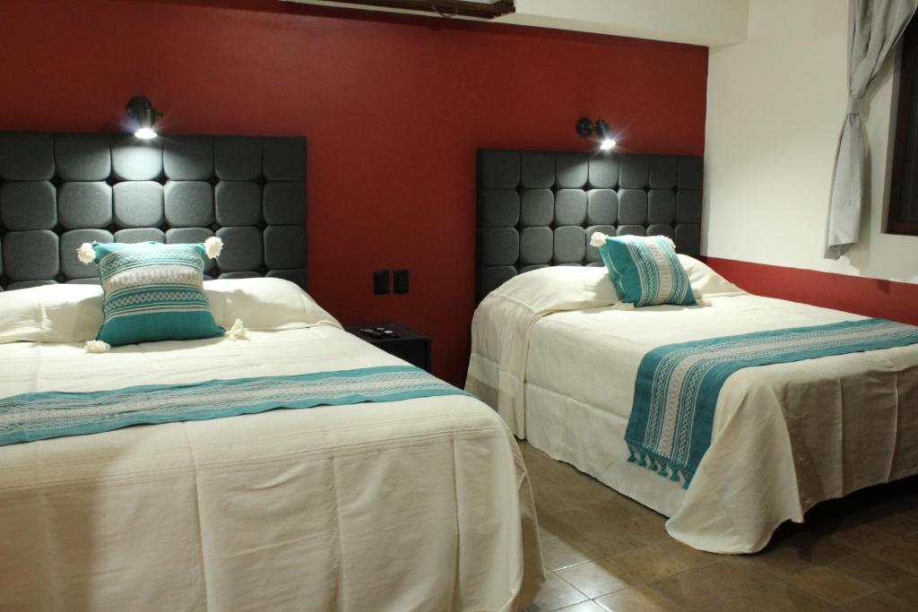 瓦哈卡市Lidia Anturios的一间卧室设有两张床和红色的墙壁