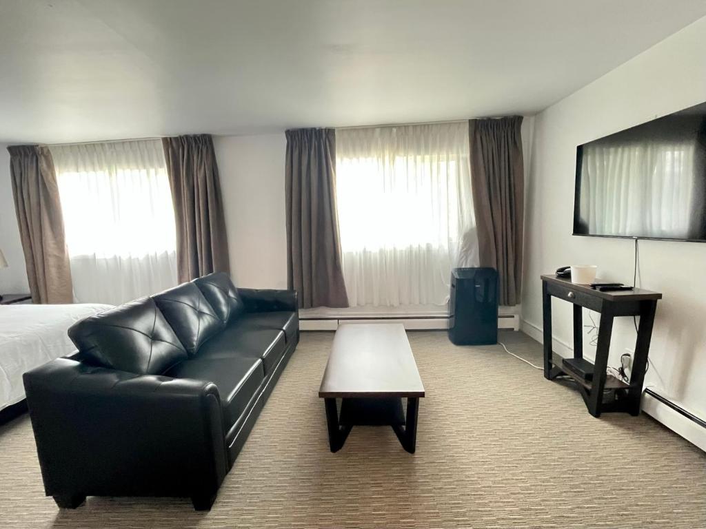 乔治王子城Anavada Inn & Suites - Prince George的酒店客房设有沙发、床和桌子。