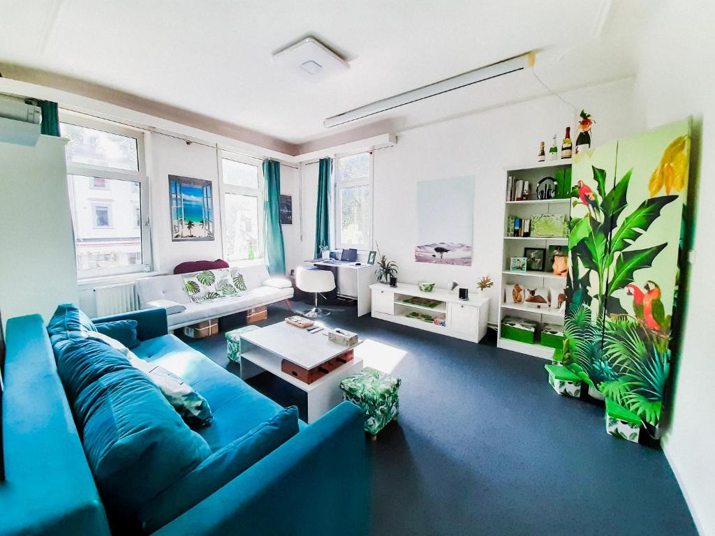 哥廷根Goethes Haus的客厅设有蓝色的沙发和一些窗户。