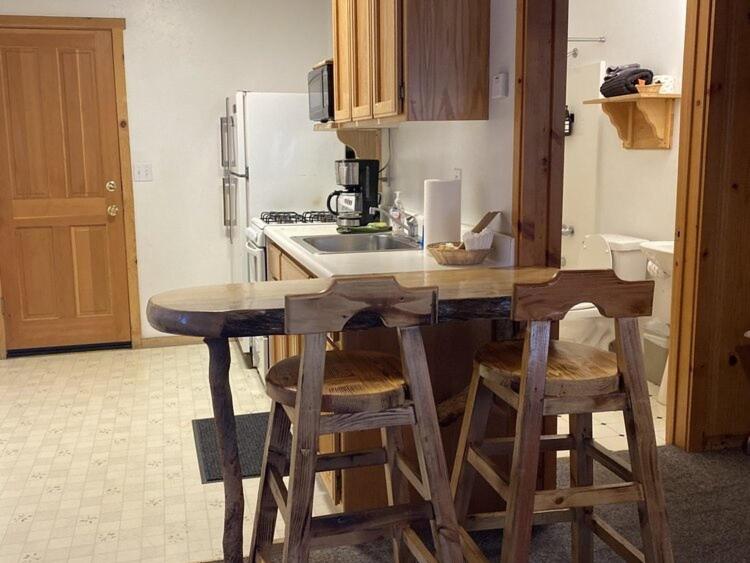 大熊湖2410 - Oak Knoll Duplex Studio #12 cabin的厨房配有带凳子和水槽的台面