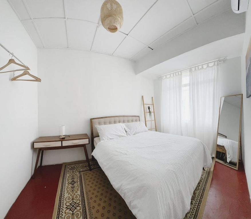 莎阿南The Classy RomaAkar的白色卧室配有床和镜子