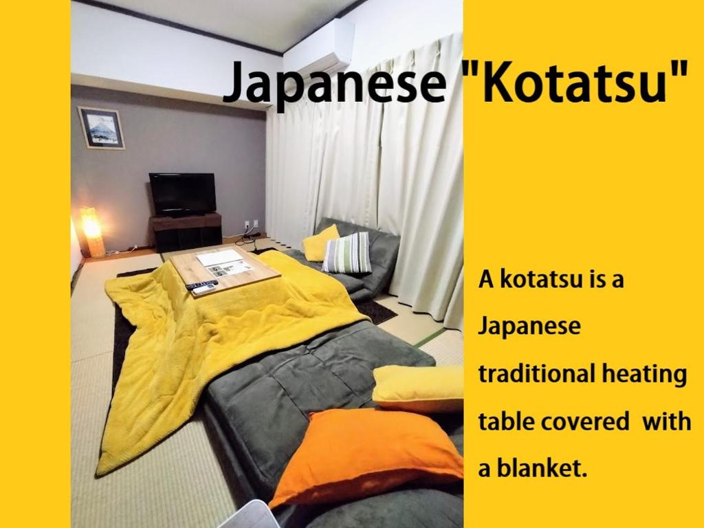 东京板橋 RCアネックス Rc306的配有一张黄色毯子的床的房间