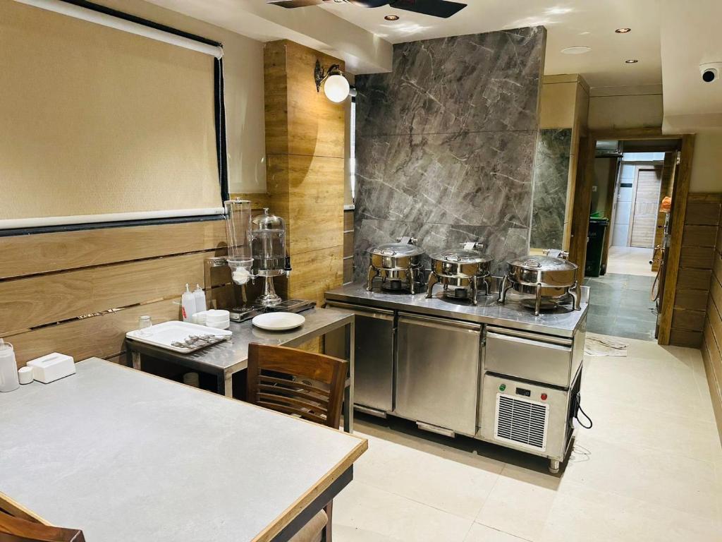 孟买HOTEL AMBER PARAMOUNT的厨房配有盆和平底锅