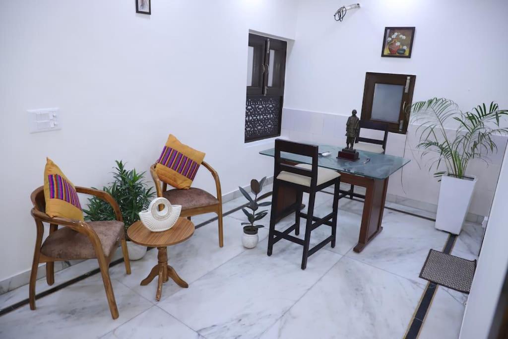 新德里divine India Service Apartment 1Bhk,L-36B,Saket的配有椅子、桌子和镜子的房间