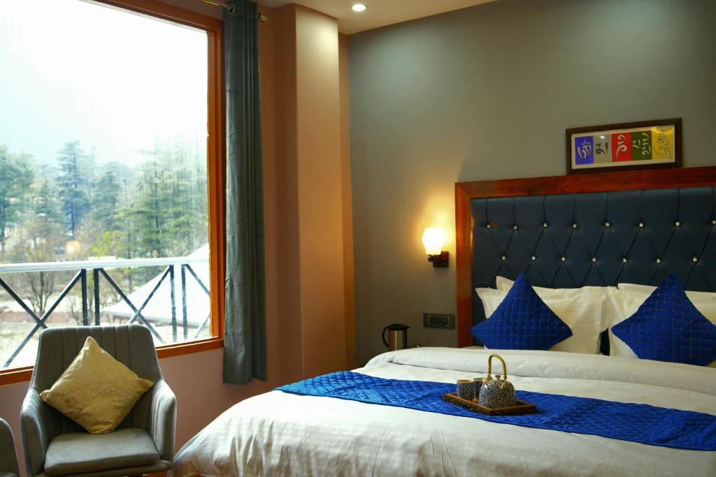 卡索尔Kasol ArtHouse - The Treasure of Himalayas的卧室配有床、椅子和窗户。