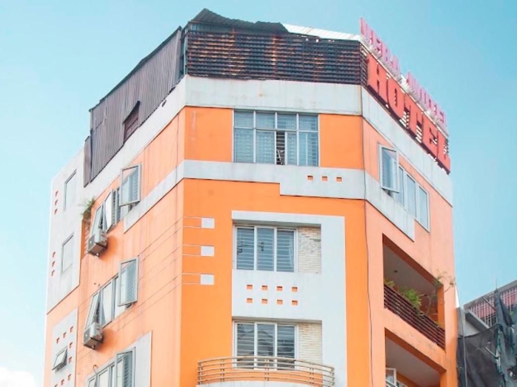 河内Vera Hotel Hà Nội的一座橙色和白色的建筑,上面有标志