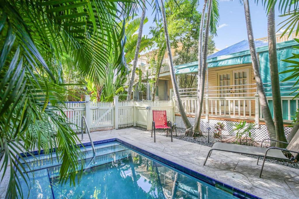 基韦斯特Paradise Place by AvantStay Key West Old Town Condo w Shared Pool的一座带游泳池和棕榈树的房子