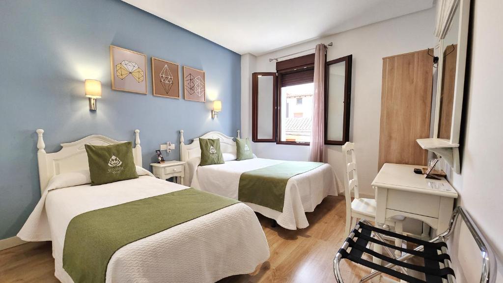 托莱多Eco Hotel Toledo的酒店客房设有两张床和窗户。