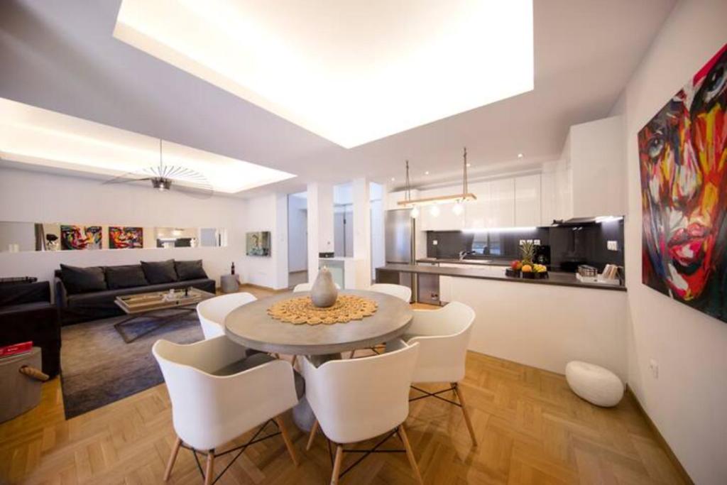 雅典GLAMOROUS APARTMENT IN KOLONAKI CENTER的厨房以及带桌椅的起居室。