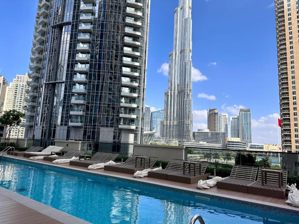 迪拜Burj Khalifa view - Modern 1BDR apartment的一个带躺椅的游泳池,享有城市天际线