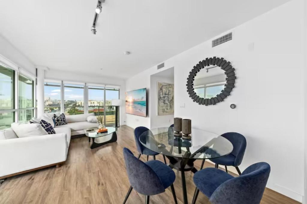 洛杉矶Luxurious SM Penthouse with Panoramic Ocean Views的客厅配有玻璃桌和蓝色椅子