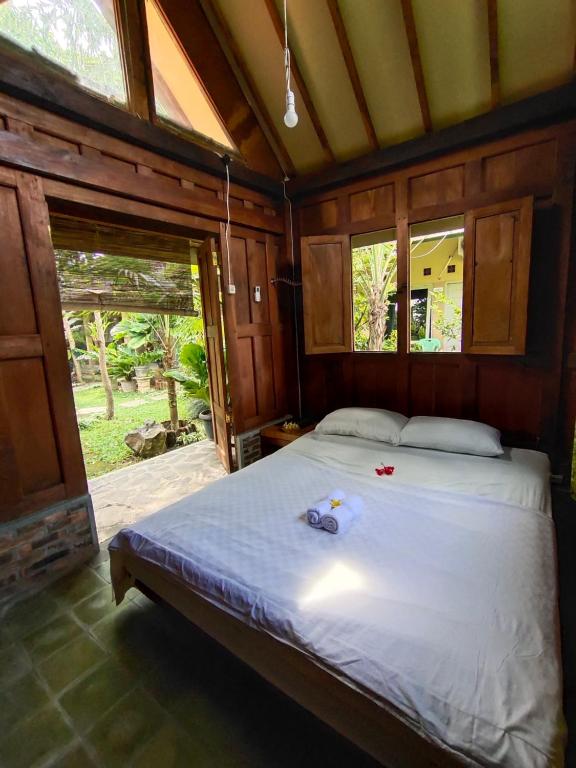 马格朗Mettaloka Guesthouse的一间设有床铺的卧室,位于带窗户的房间内