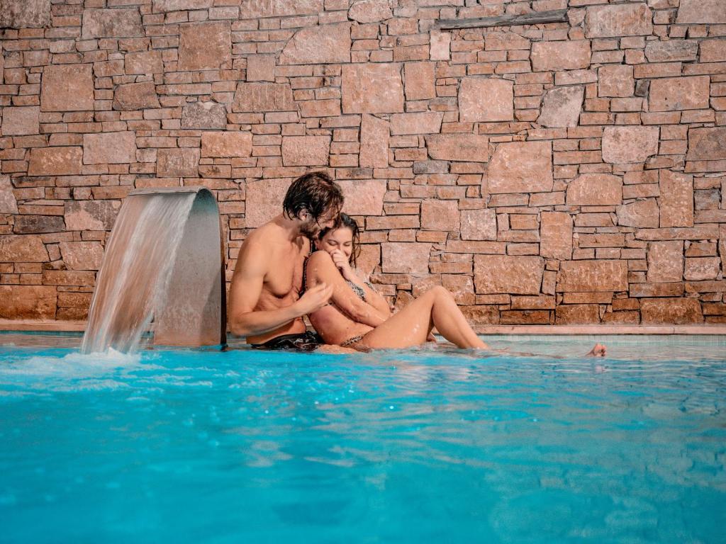 尼亚·卡利克拉提亚秘密天堂Spa酒店的坐在游泳池里的男人和女人