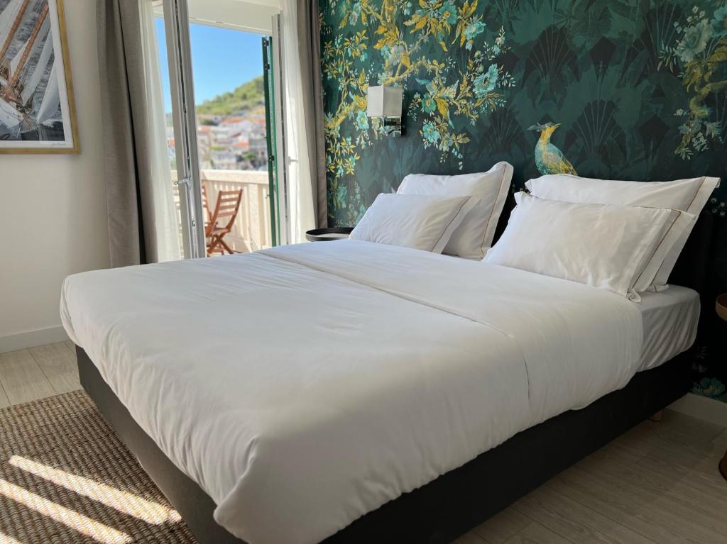 扎顿Adriana Zaton的卧室内的一张带白色床单和枕头的大床